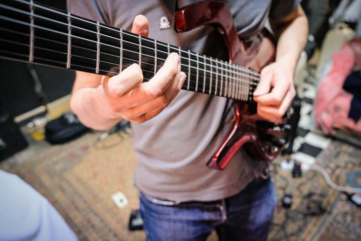 leisure activities man in grey shirt playing guitar musical instrument